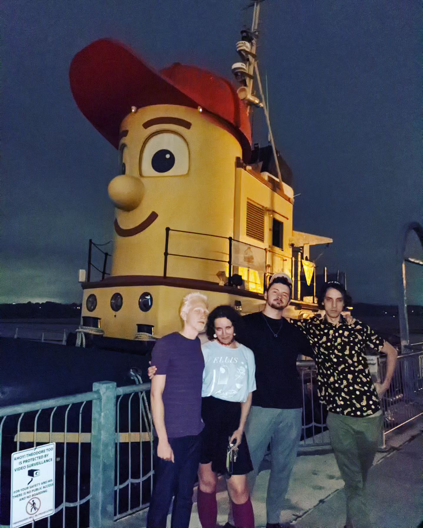 Junestone band members standing in front of a tugboat