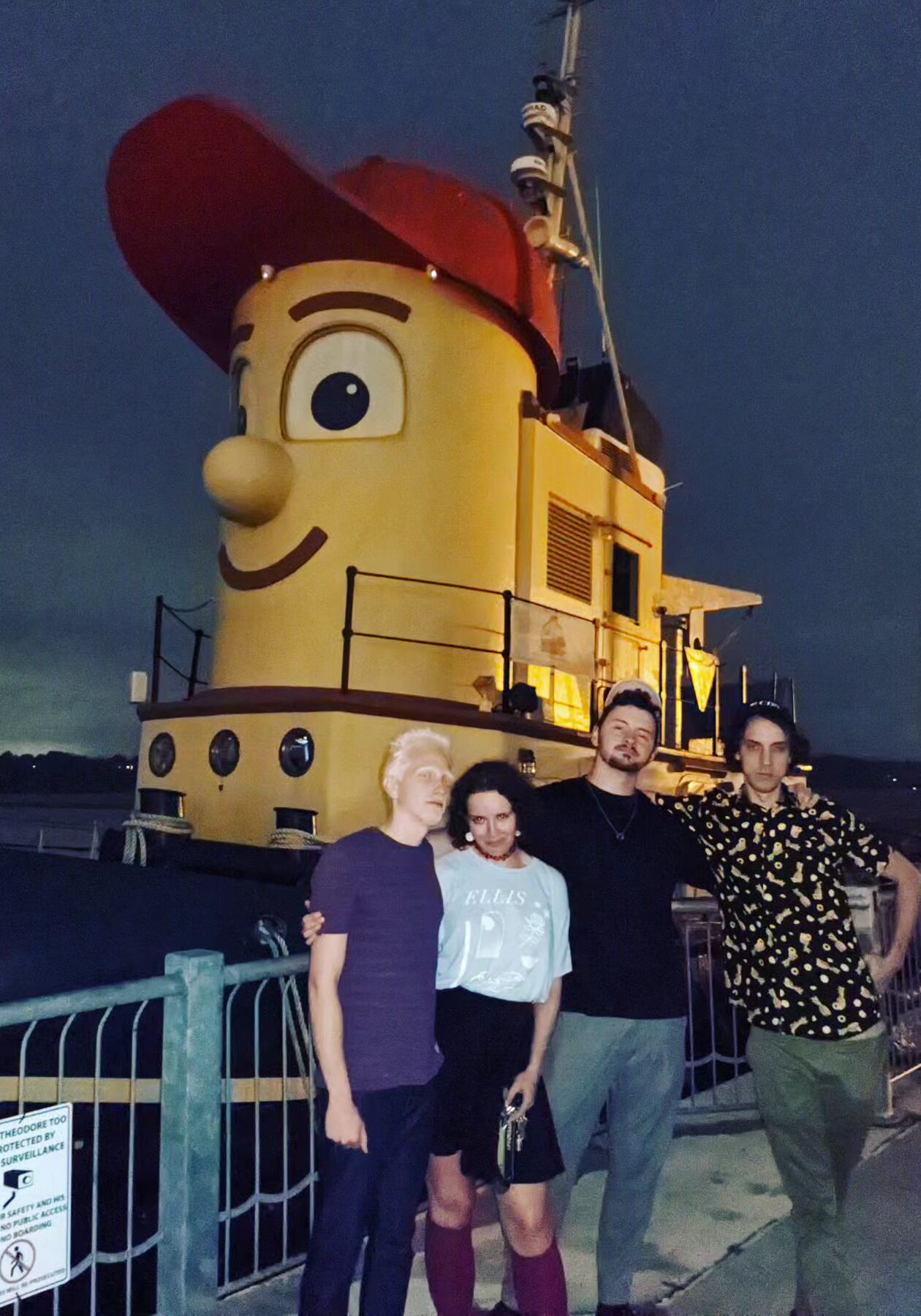 Junestone band members standing in front of a tugboat